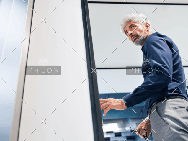 demo-attachment-914-mature-businessman-in-the-office-standing-P4MENHG